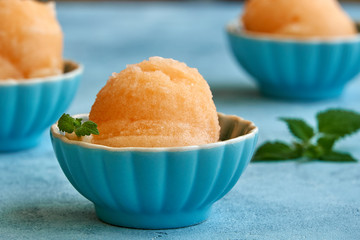 Homemade melon, apricot or peach ice cream , sorbet in bowl with mint leaves. Closeup - obrazy, fototapety, plakaty
