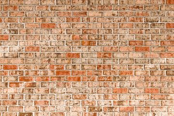 Brick wall with light orange and brown bricks for background.