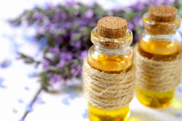 Lavender oil and lavender flowers on white background