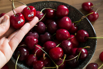fresh cherry in the ceramic bowl on the table for summer fruits concept.