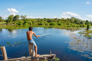 Fototapeta premium Jovem pescador solitario com vara debaixo de sol