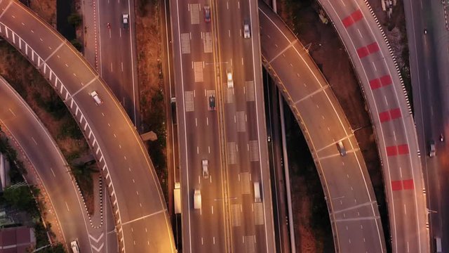 Aerial drone night shot of urban elevated toll ring road junction, express way and interchange overpass passing in Thailand