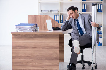 Leg injured male employee in the office 
