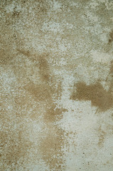 Worn wall covered by rough plaster with some chipped