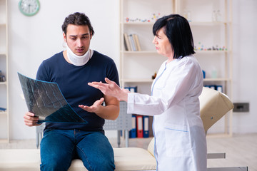 Young male patient visiting aged female doctor 