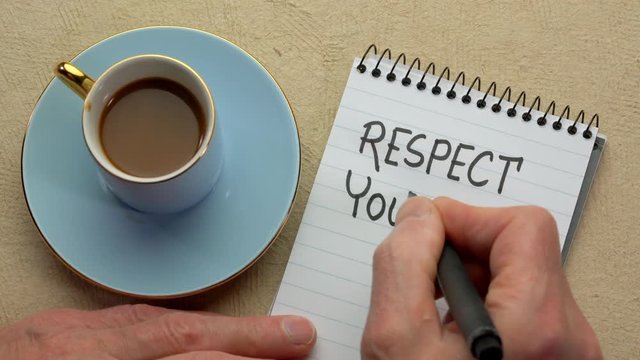 Respect yourself - man hand writing a note with a black marker in a spiral notebook, overhead view