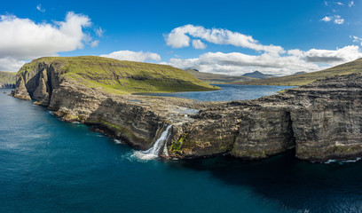 Fototapeta na wymiar Bosdalafossur waterfall on Vagar island coastline aerial view, Faroe Islands
