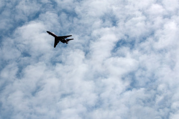 the plane flies across the blue sky