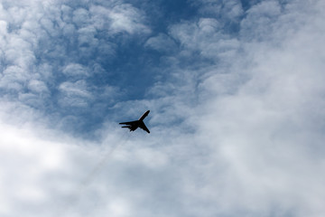 the plane flies across the blue sky