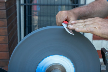 Knife sharpening hand and sanding machine close-up.