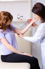 Female doctor checking patient's joint flexibility with goniomet