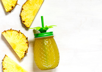 Pineapple juice and slices of fresh pineapple, top view, copy space