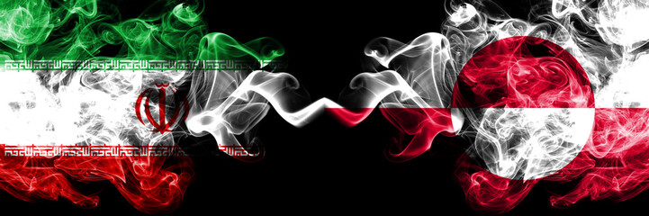 Iran vs Greenland smoky mystic states flags placed side by side. Thick colored silky smokes flag combination of Iranian and Greenland