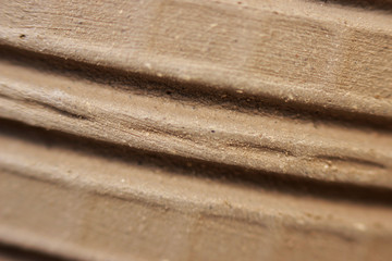 side wall of a red clay pot with stripes made for decoration and texture. dried and unburned product. macro.
