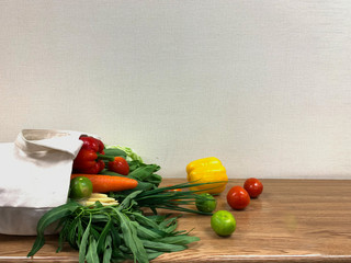 Many farm Fresh Vegetables in the sack bag on the rustic table, Spilled vegetables and fruit in a cotton textile bag or sackcloth Eco-bag holding, old wooden background