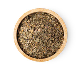 dried parsley in wood bowl isolated on white background. top view