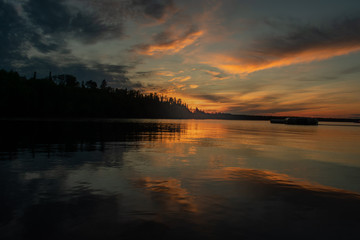Naklejka premium Sunset with clouds reflected on water