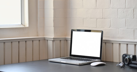 Mock up laptop with blank screen on workspace