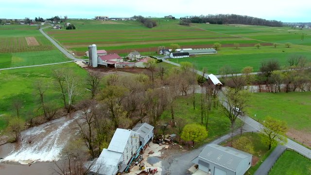 Rapids on small river and a covered bridge in American countryside, farms and houses on the banks, Conestoga river and Bitzer's Mill covered bridge in Lancaster county, Pennsylvania