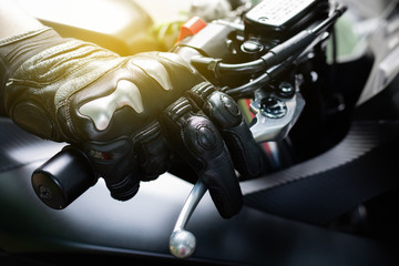 Close up of throttle control hand and brake lever motorcycle, Hands wearing black leather gloves with a protective card grip the brake lever - obrazy, fototapety, plakaty