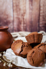 several chocolate cupcakes on a wooden background decorated with fabric