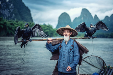 Cormorant fisherman in Traditional showing of his birds on Li river near Xingping, Guangxi...