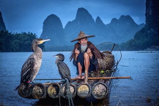 Cormorant fisherman in Traditional showing of his birds on Li river near Xingping, Guangxi province, China.