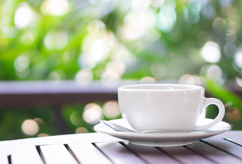 Closeup hot americano coffee on glass table with green nature background