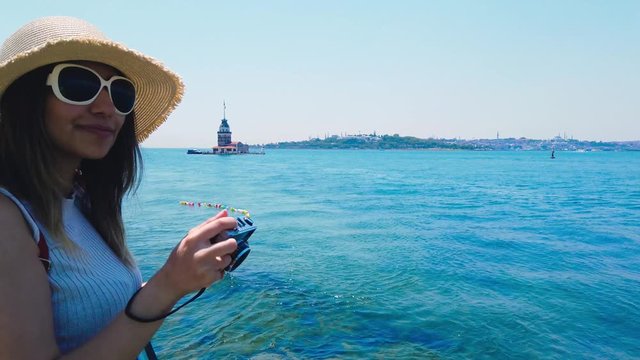 Beautiful girl takes pictures of Bosphorus,a popular destination in Uskudar town,Istanbul,Turkey
