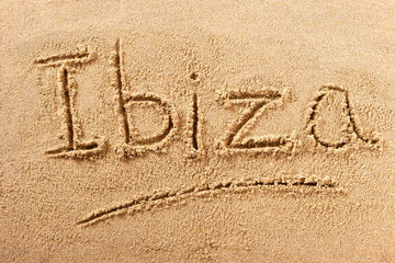 Ibiza word written in sand on a sunny spanish spain summer beach holiday vacation travel destination sign writing message photo