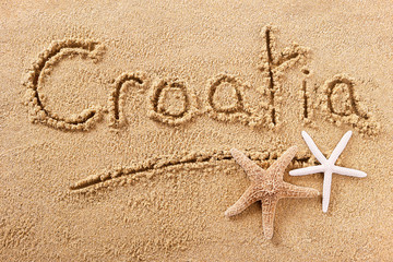 Fototapeta na wymiar Croatia word written in sand on a sunny beach with starfish holiday vacation travel destination sign writing message photo