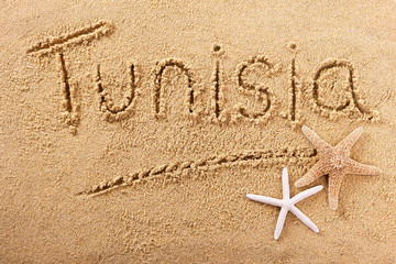 Tunisia word written in sand on a sunny summer beach with starfish holiday vacation travel...