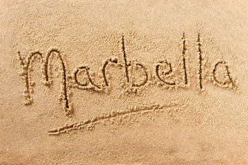 Marbella word written in sand on a sunny spanish spain summer beach holiday vacation travel destination sign writing message photo