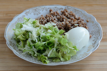 delicious buckwheat porridge with butter and boiled chicken egg, delicious and nutritious Breakfast, food close-up