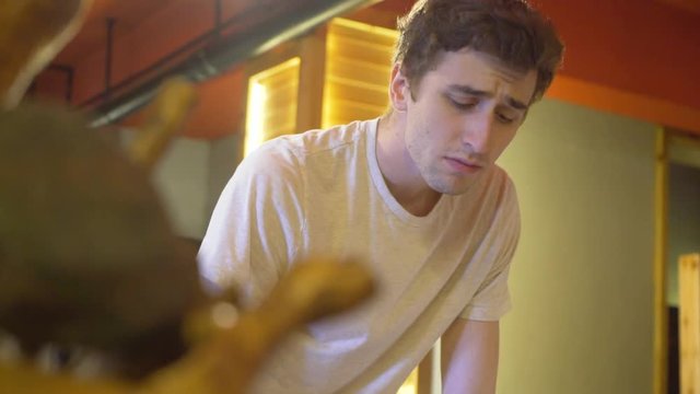 Slow motion shot of a young, caucasian man in a studio is busy working with a traditional Chinese huzhou brush