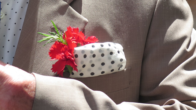 Smartly dressed man with red carnation