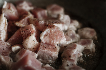 meat is fried in hot oil in a cast iron pot, roasted meat, meat preparation process, fried meat with spices