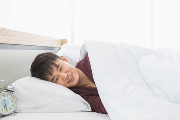 Fototapeta na wymiar Asian man lie on one's side on the bed..
