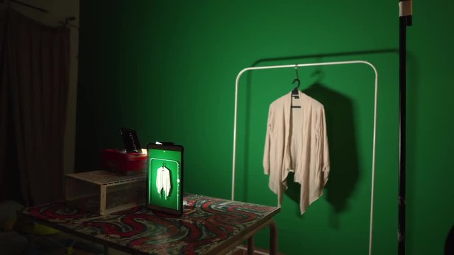 Mother selling clothing online hanging and photographing items in dark room fashion time
