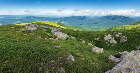 beautiful summer panorama in mountains. grassy meadows, rocks and mountain range in the distance.