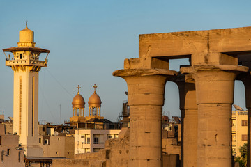 Obraz premium catholic Church and Muslim Mosque Tower religion Symbols together in Luxor temple at sunset