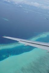 Fototapeta na wymiar View from the window of the plane to the Maldives with airplane's wing