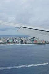 Fototapeta premium View from the window of the plane to the Maldives with airplane's wing