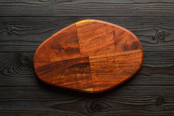 empty cutting board on a rustic wooden table, top view