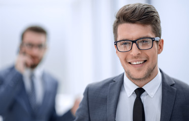 close up.smiling young businessman in the office background