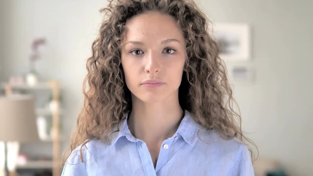 Thumbs Down by Curly Hair Woman at Work,  Looking at Camera