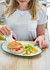 woman eating pancakes with apples