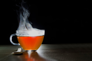 glass cup with tea infusion, on black background with label to write text