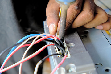 Technician is soldering the car stereo unit