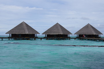 Water villas, cloudy sky and the Indian Ocean in cloudy weather